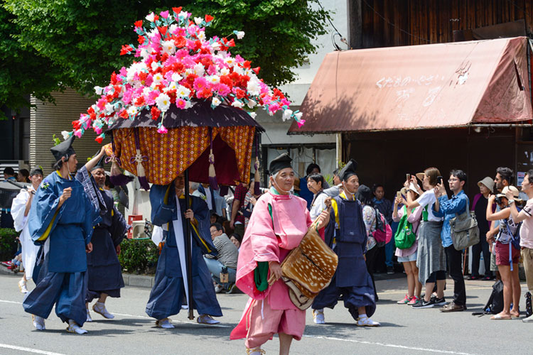 Man carrying a hollyhock float in the Aoi Matsuri procession.