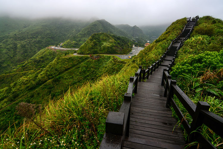 Wood boardwalk along a mountain ridge overlooking the ocean in northeast Taiwan.